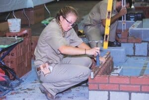 Photo of a female student doing masonry.
