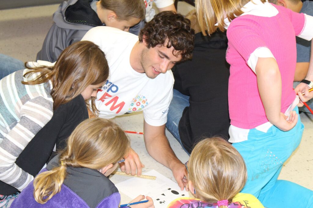 Photo of an older student mentoring younger students.