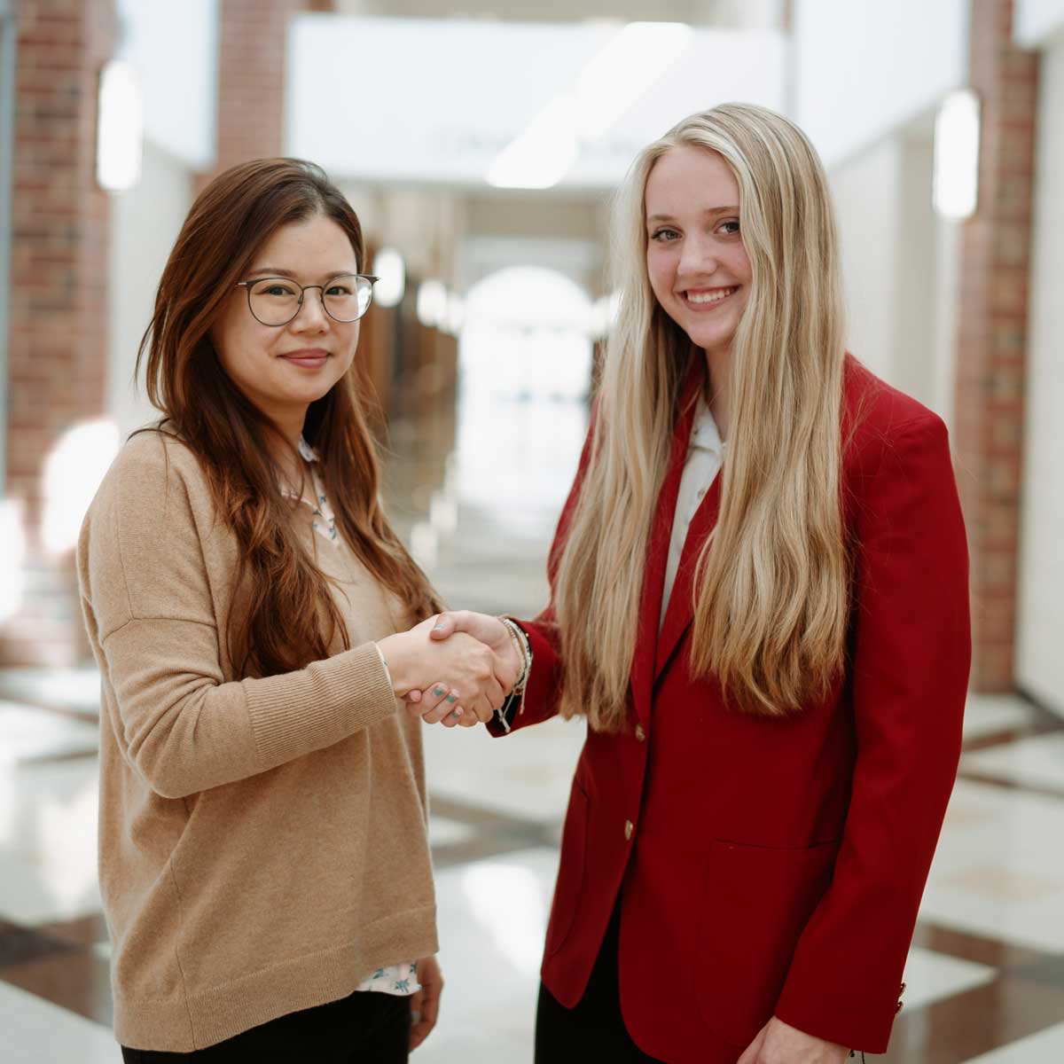 Photo of a student shaking hands with someone.