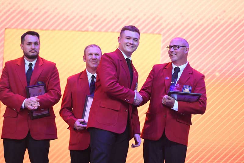 National Officer shaking hands with the 2025 Advisor of the Year, Brady Mitchell.