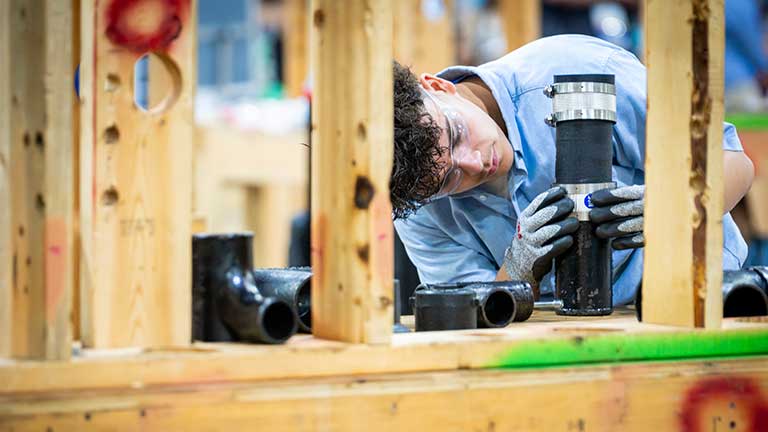 Young man installing a pipe.